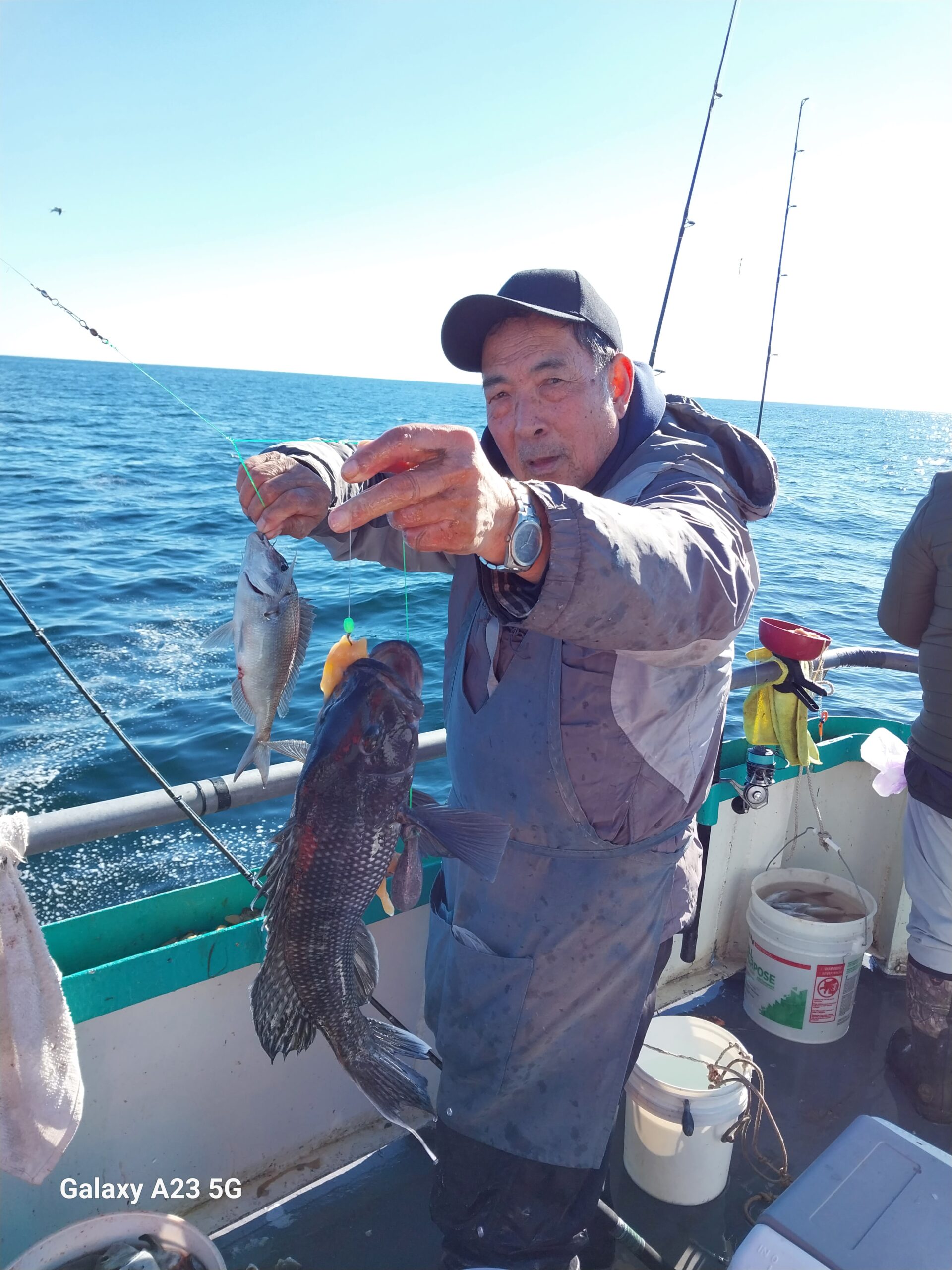 a man holding a fish on a boat in the water