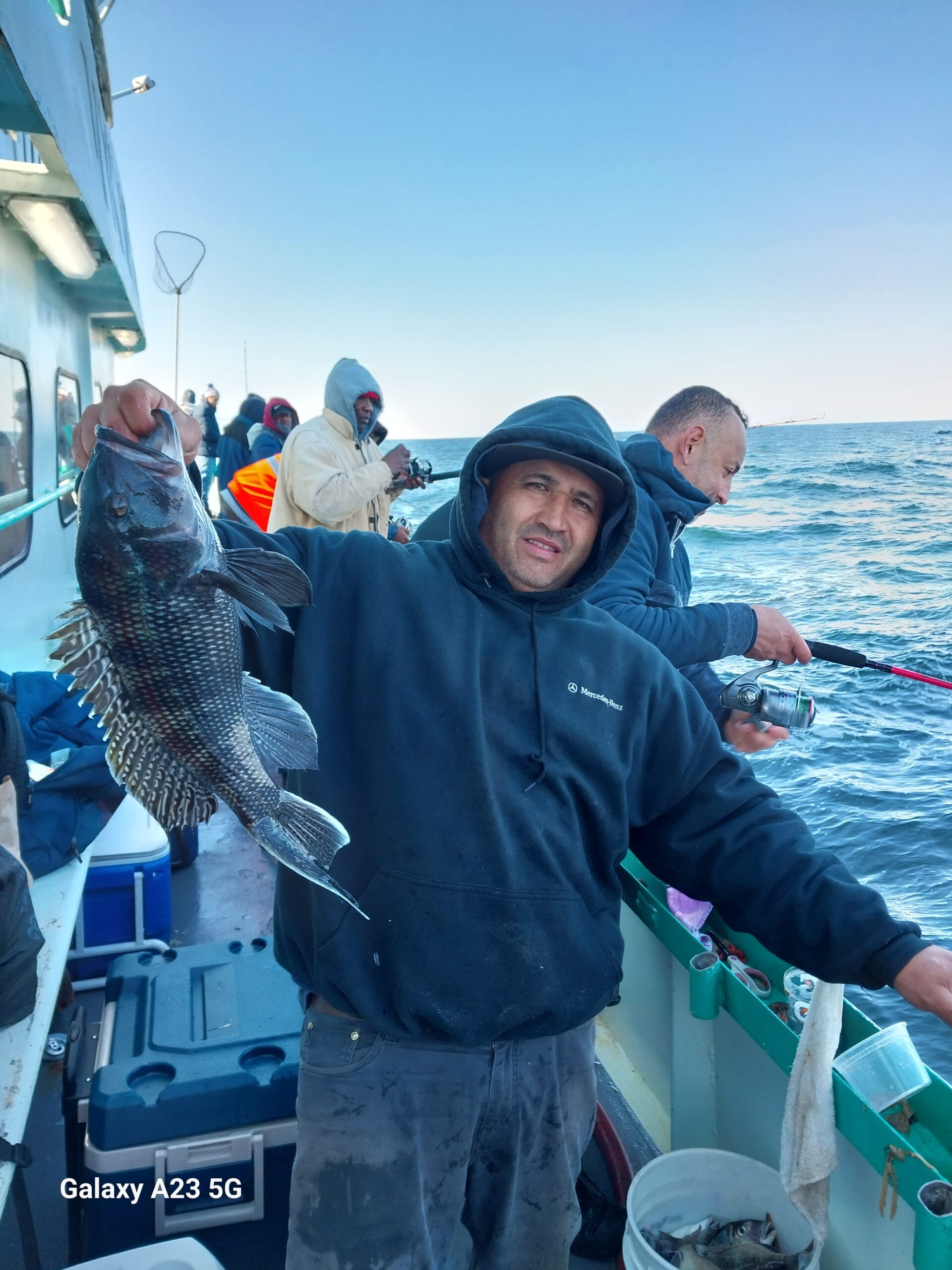 Bill O'Brien standing next to a boat