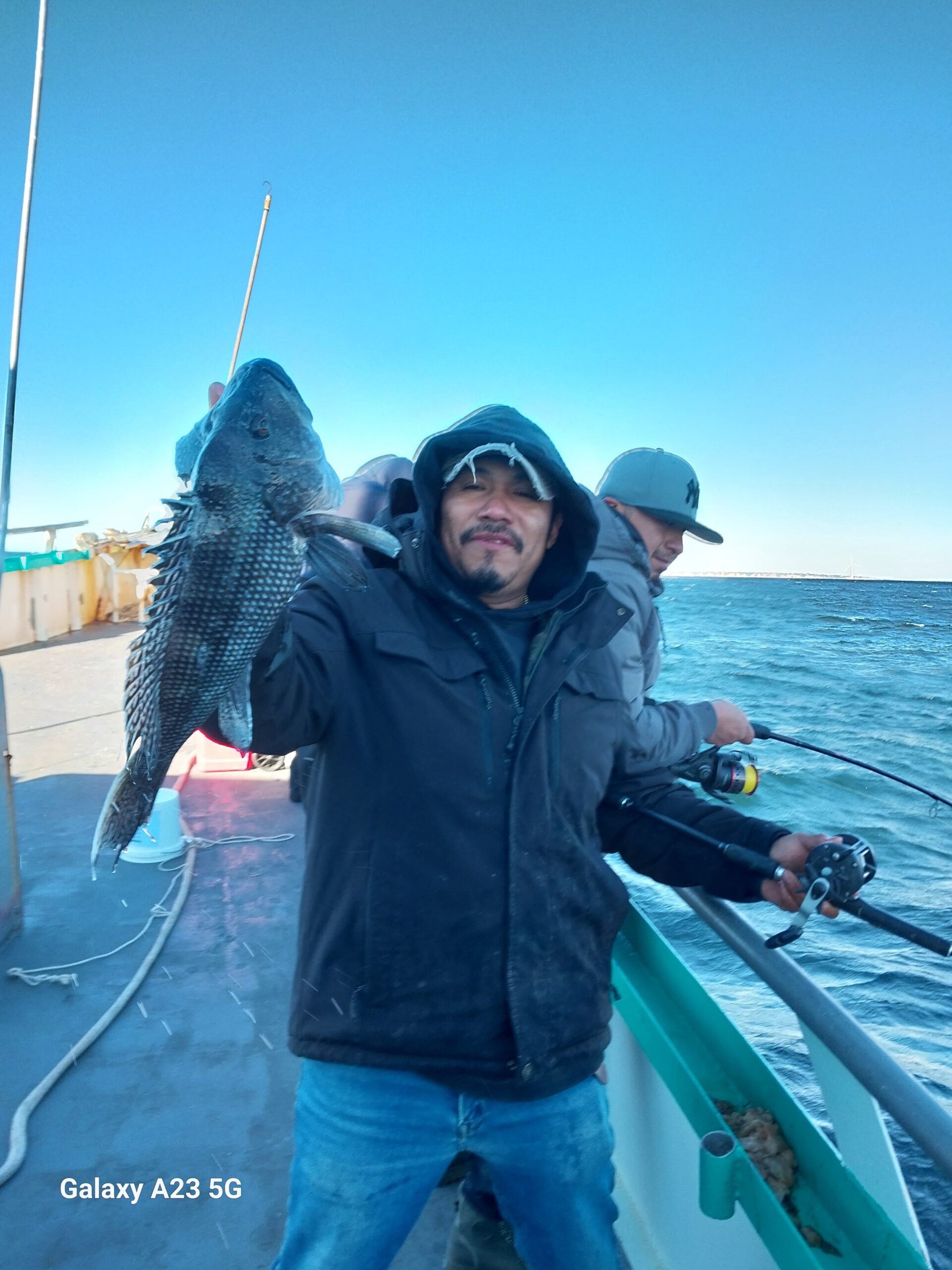 a person holding a fish on a boat in the water