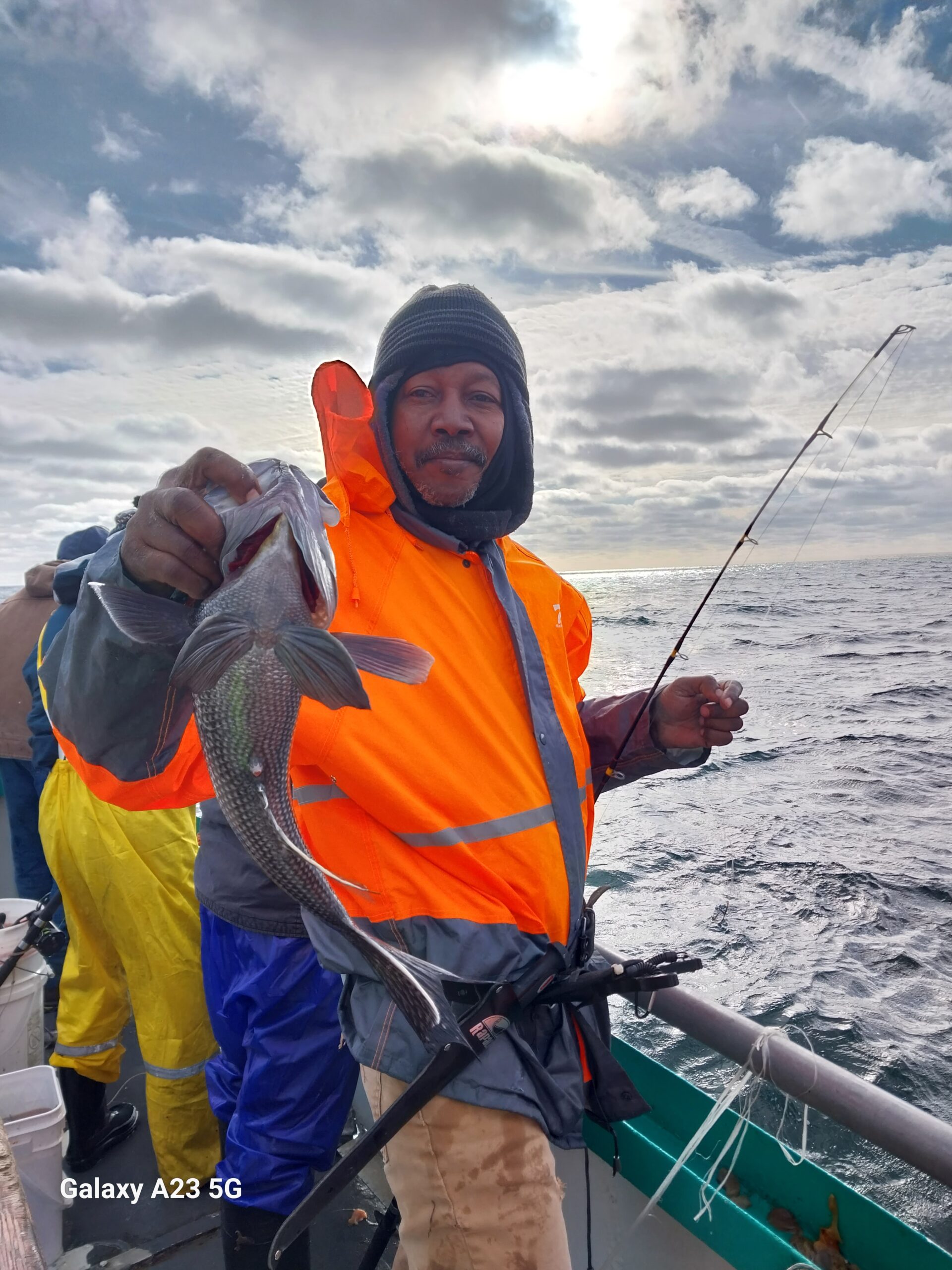a man holding a kite while standing in the water