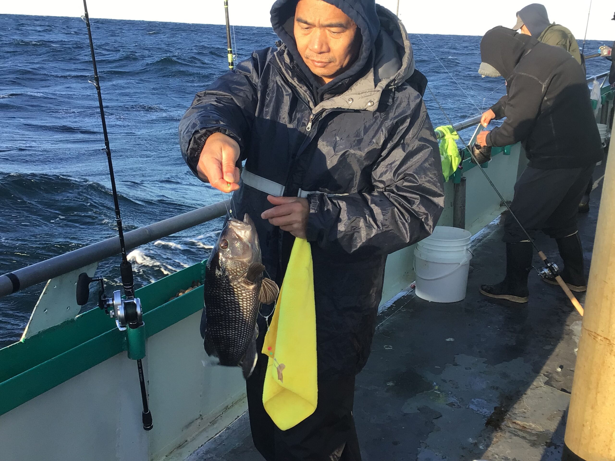 a person holding a fish on a boat in the water