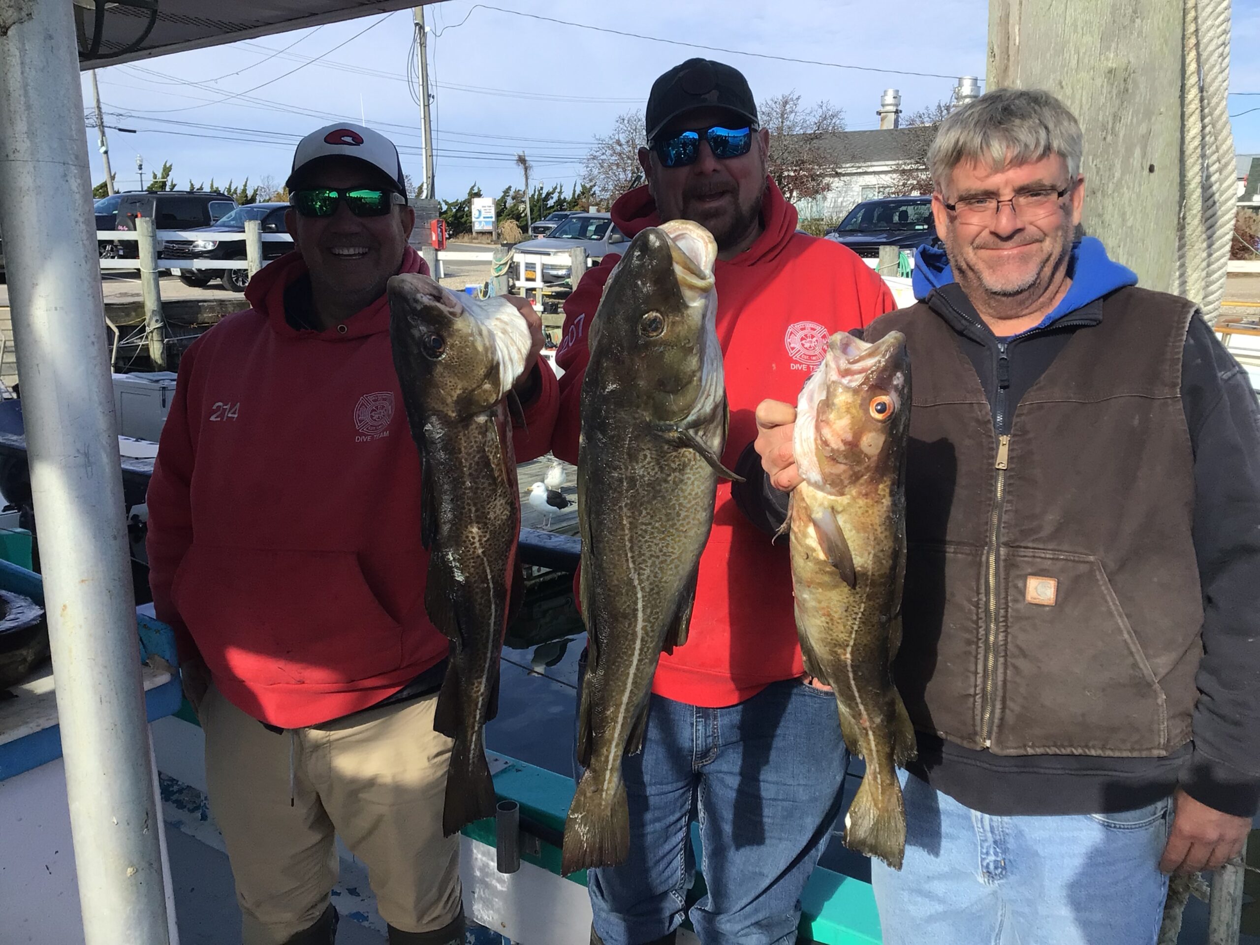 a group of people standing next to a person holding a fish