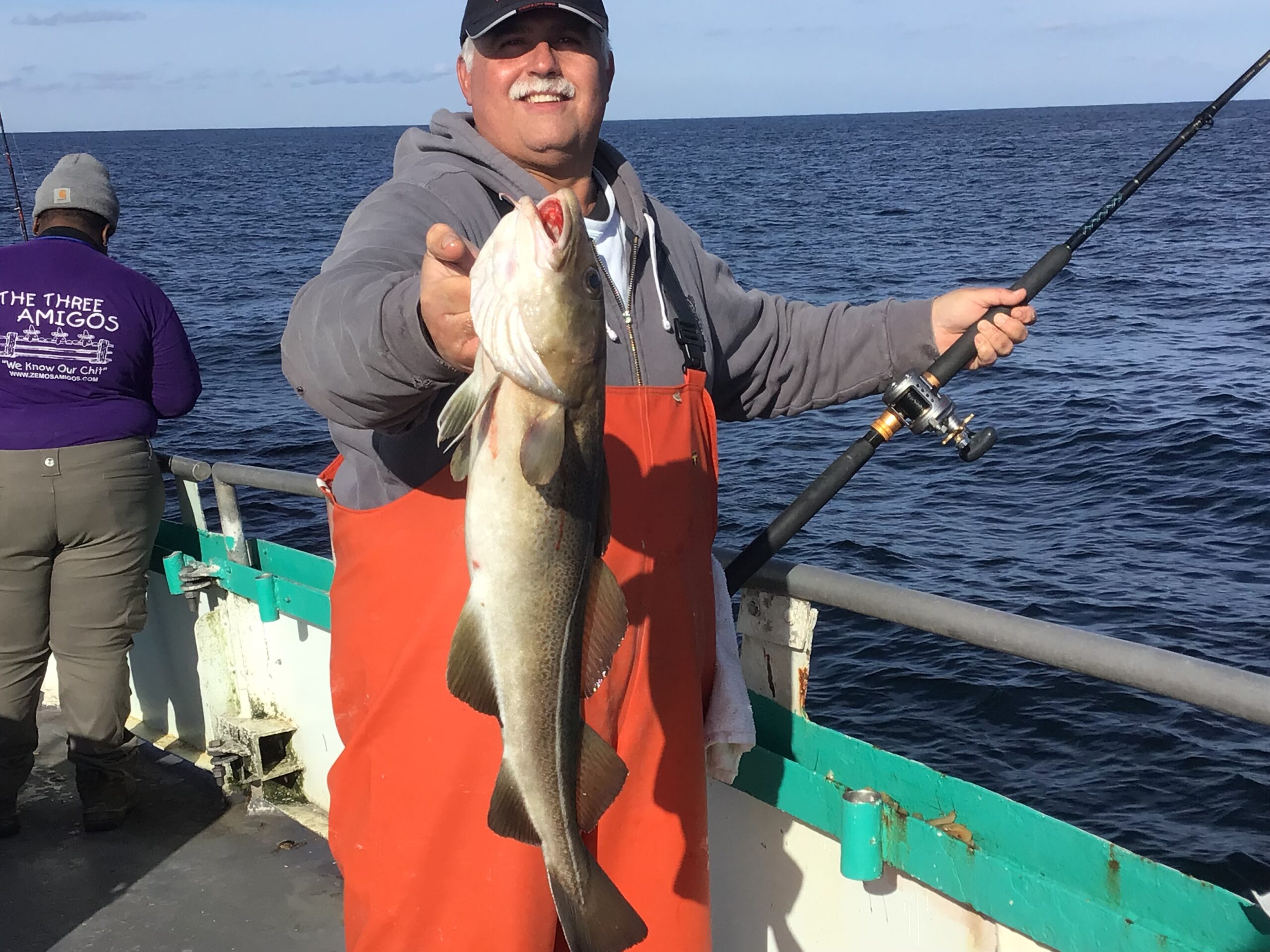 a person holding a fish on a boat in a body of water