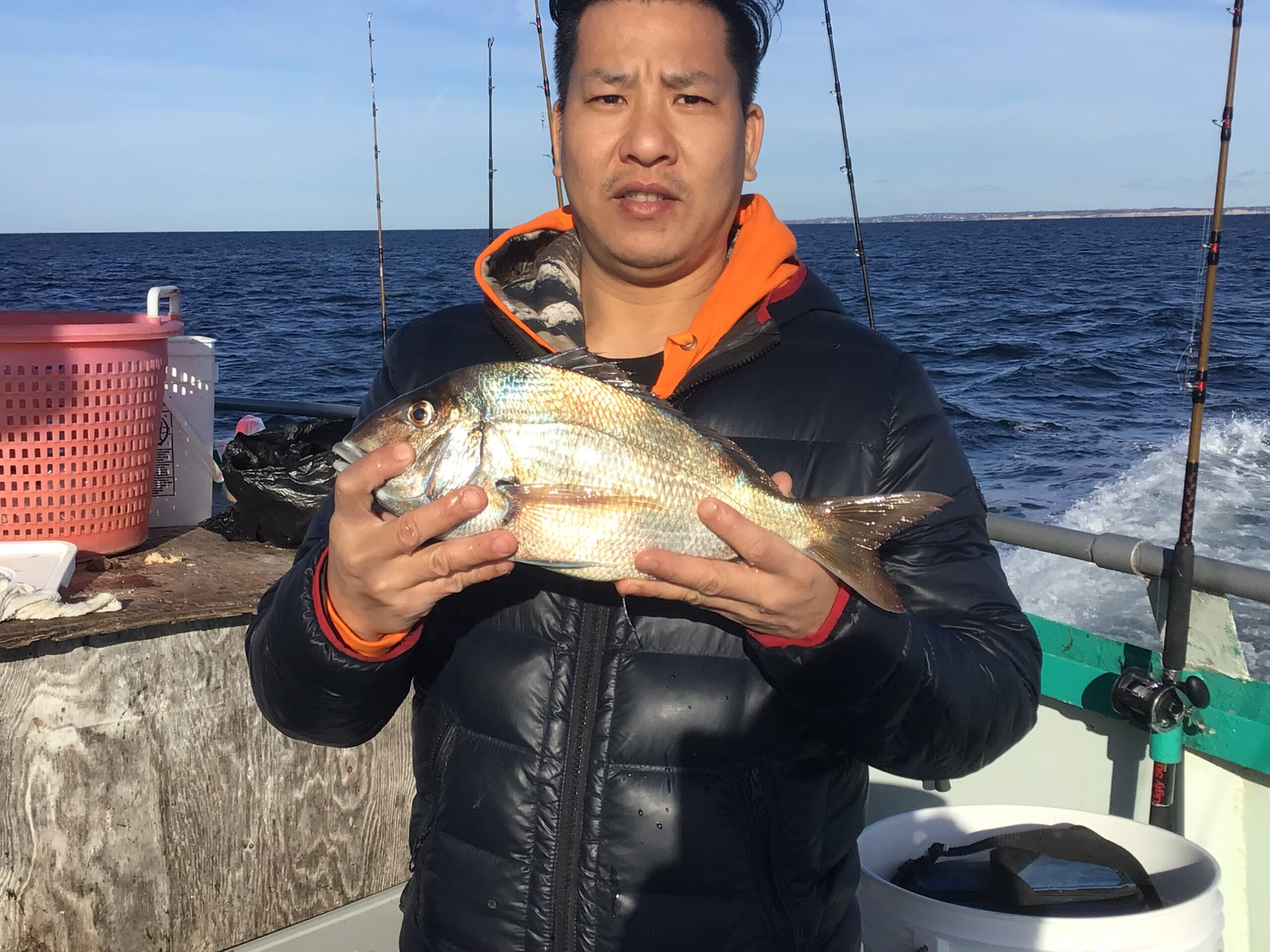 a person holding a fish on a boat in the water