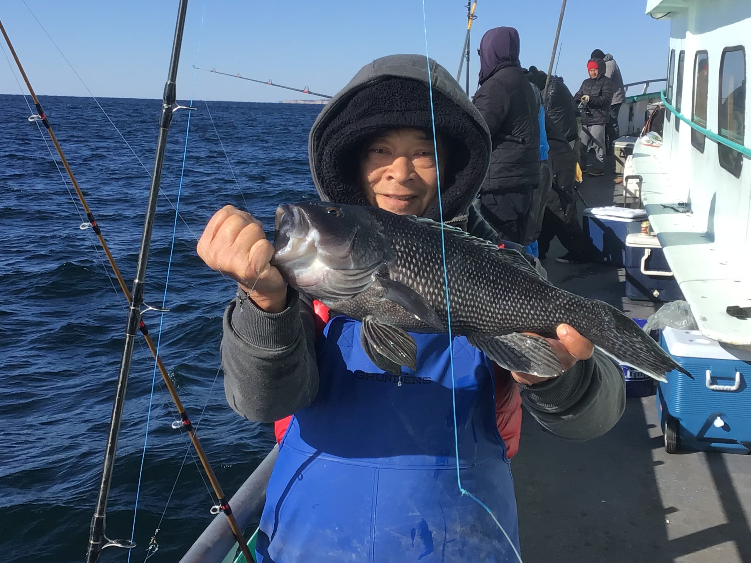 a man holding a fish on a boat in the water