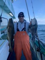 a man holding a fish on a boat