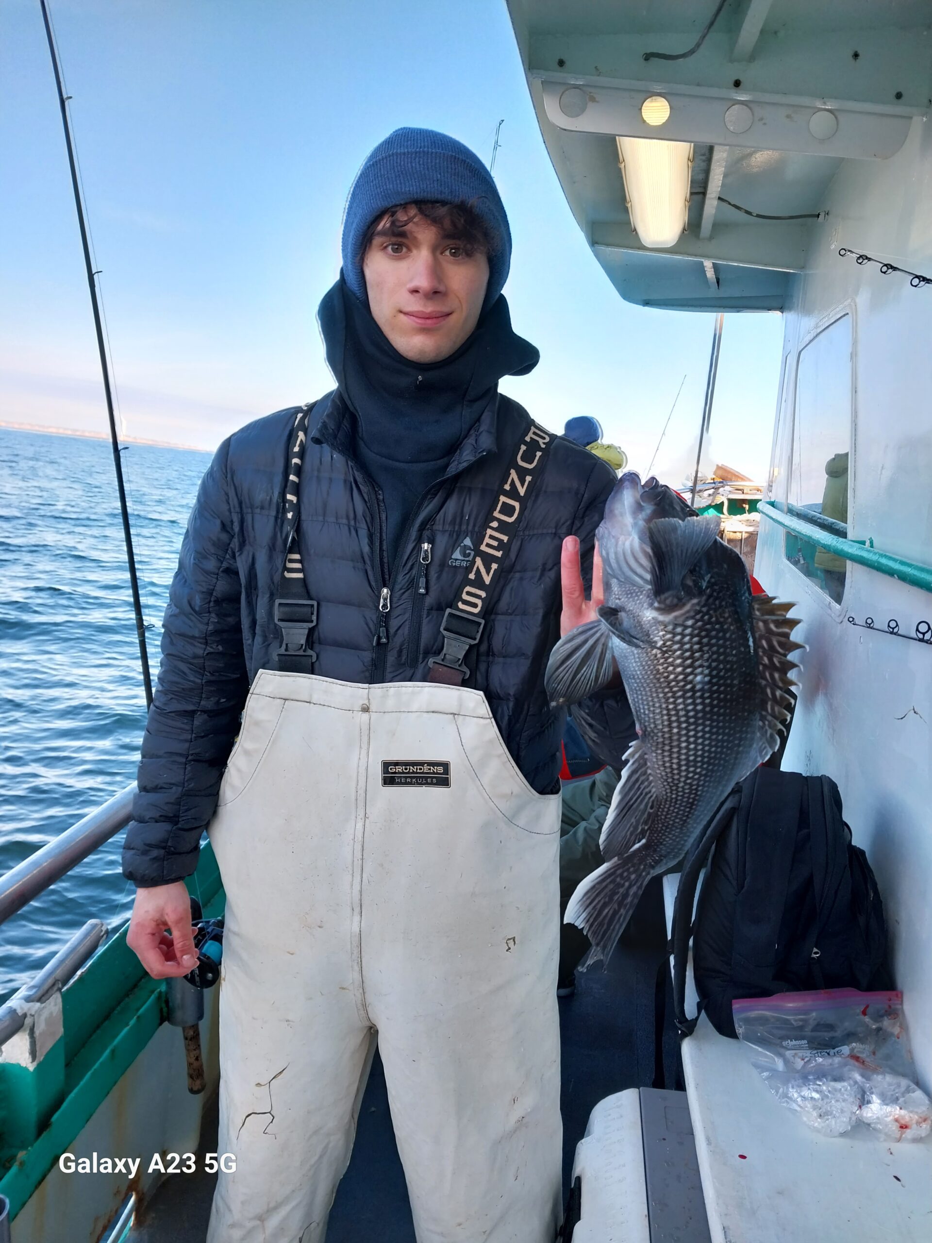 a person holding a fish on a boat