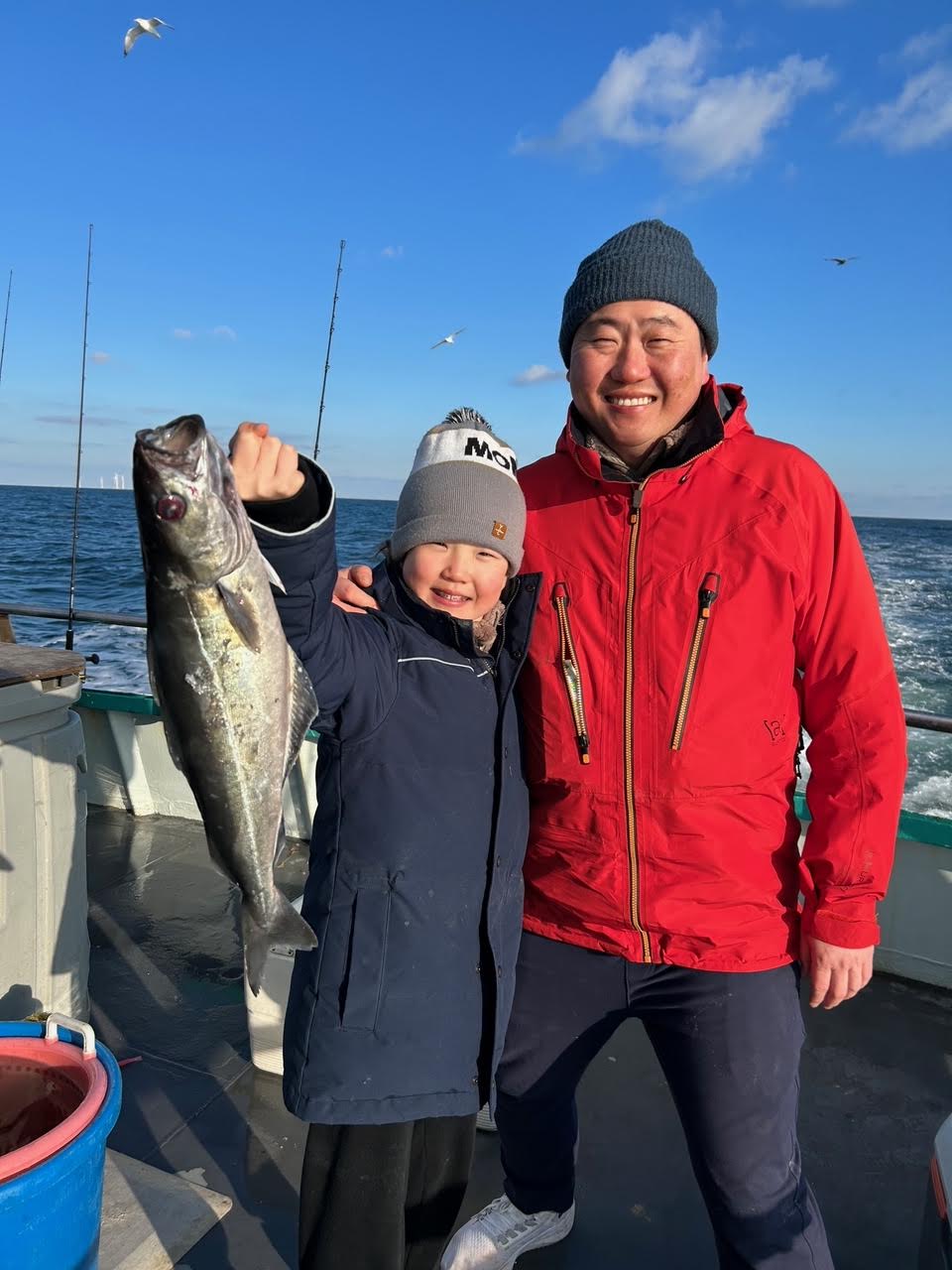 a person holding a fish posing for the camera