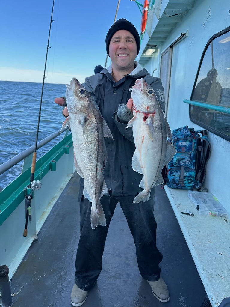 a person holding a fish on a boat