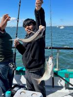 a person holding a fish on a boat in a body of water