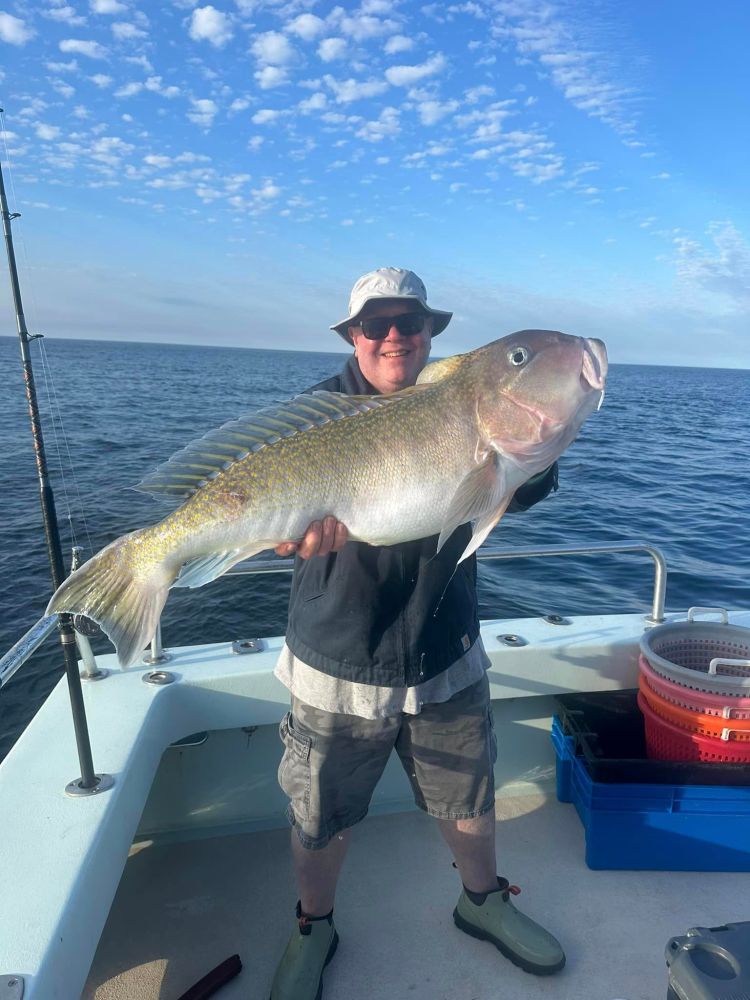 a man holding a fish in the water