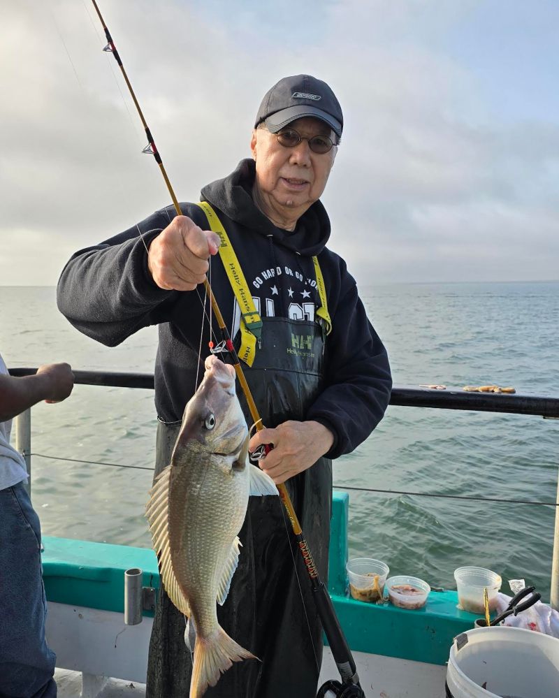 a person holding a fish on a boat in the water