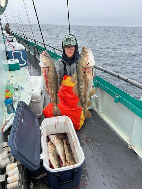 a man holding a fish on a boat