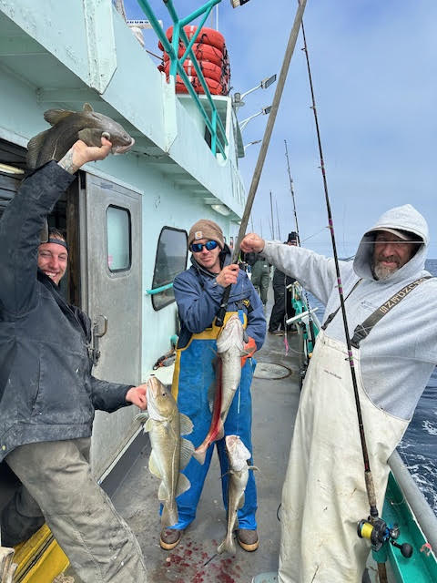 a group of people standing next to a person holding a fish