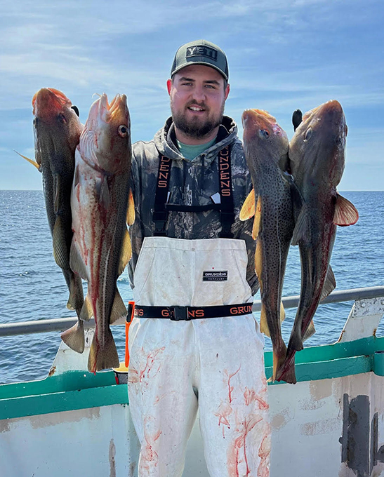 a man holding a fish on a boat