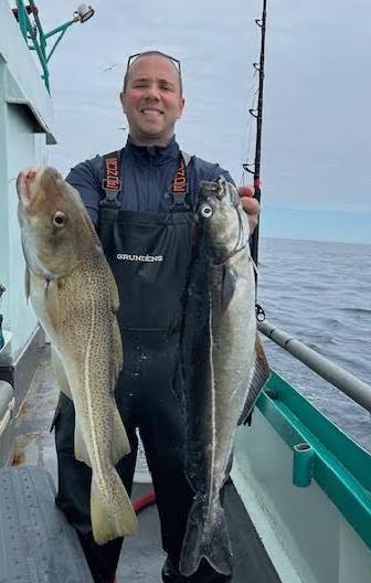 a man holding a fish on a boat