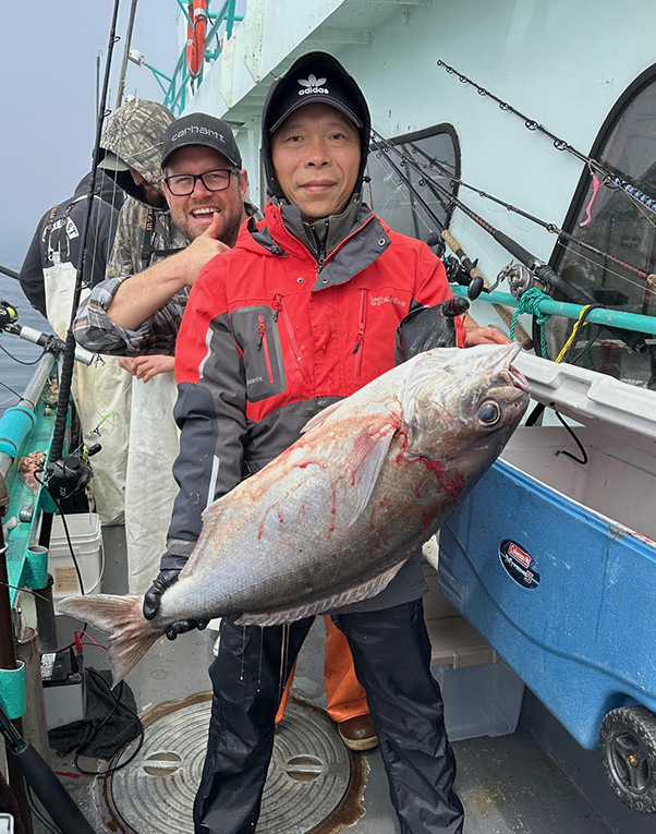 a person holding a fish on a boat