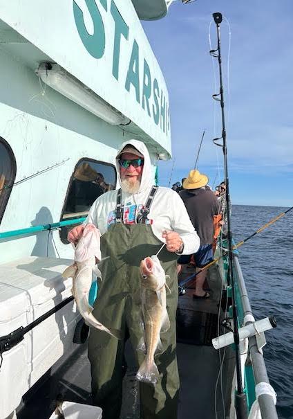 a man holding a fish on a boat