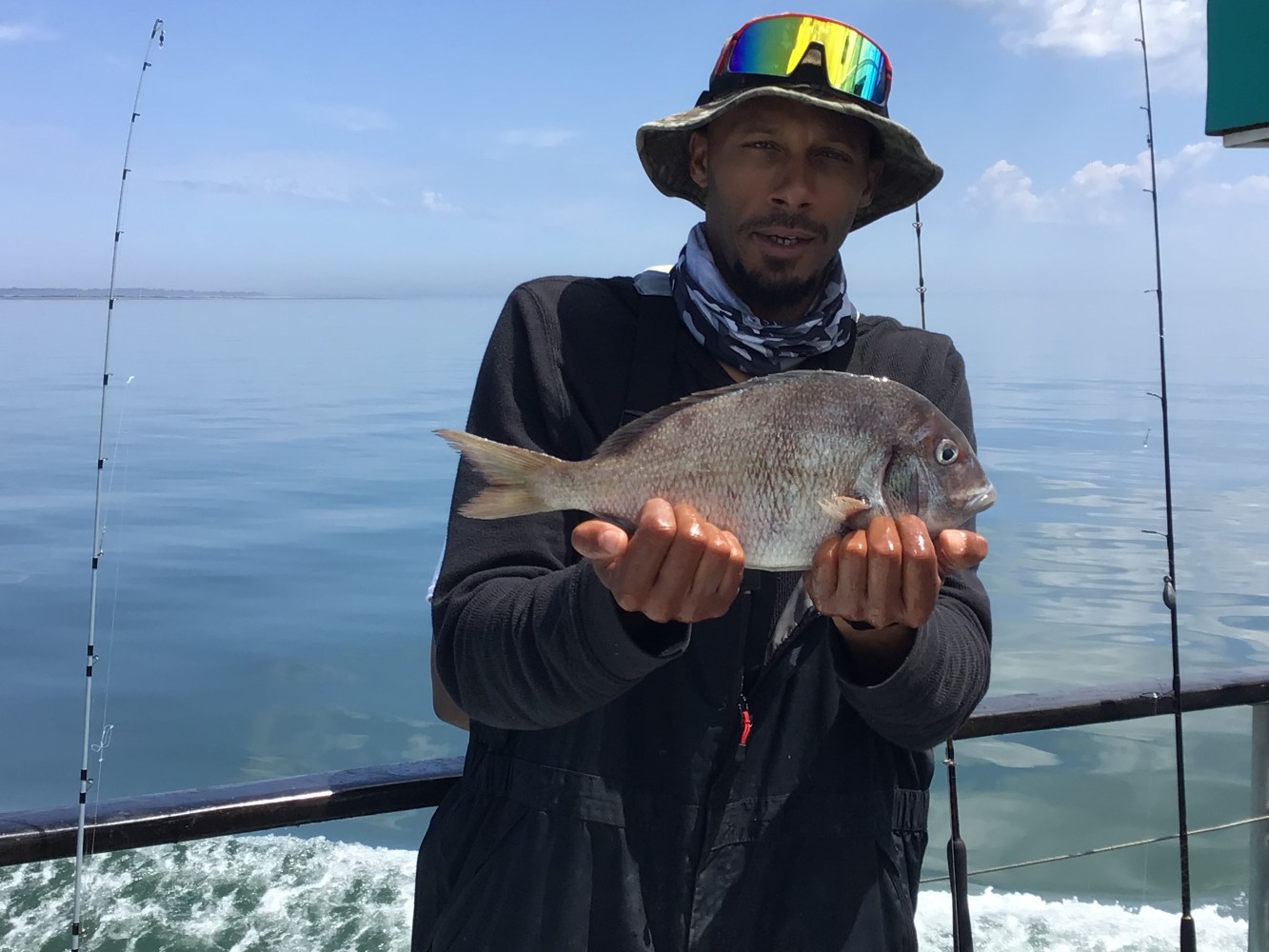 a person holding a fish on a boat in a body of water