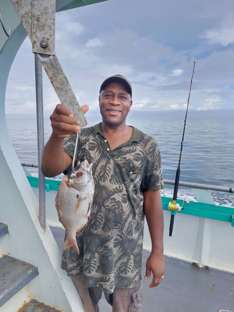 a man holding a fish in the water