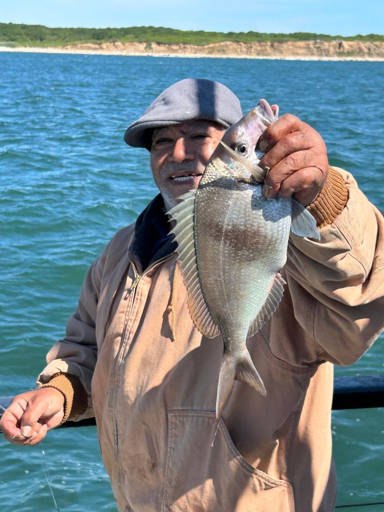 a man holding a fish in a body of water