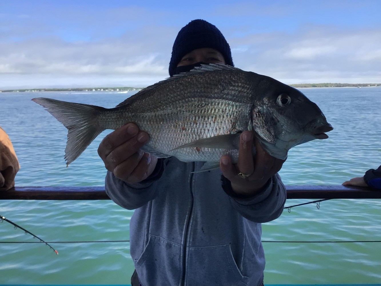 a person holding a fish on a boat in a body of water