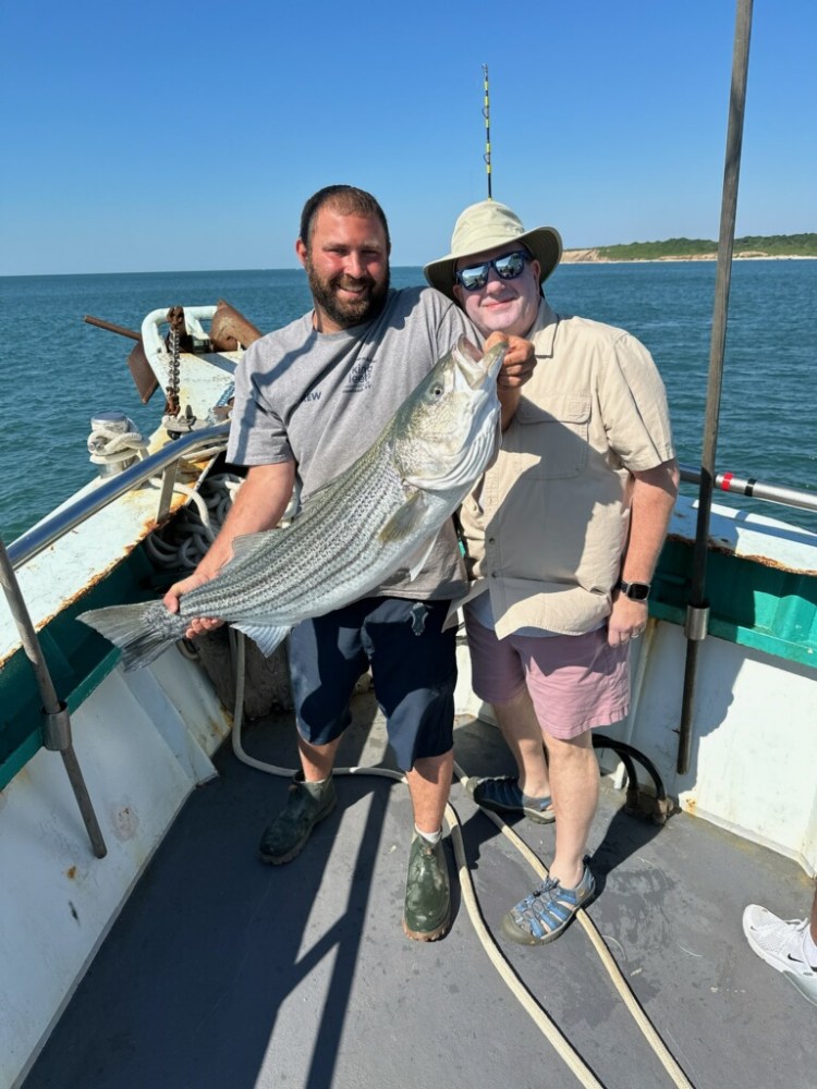 a person holding a fish on a boat