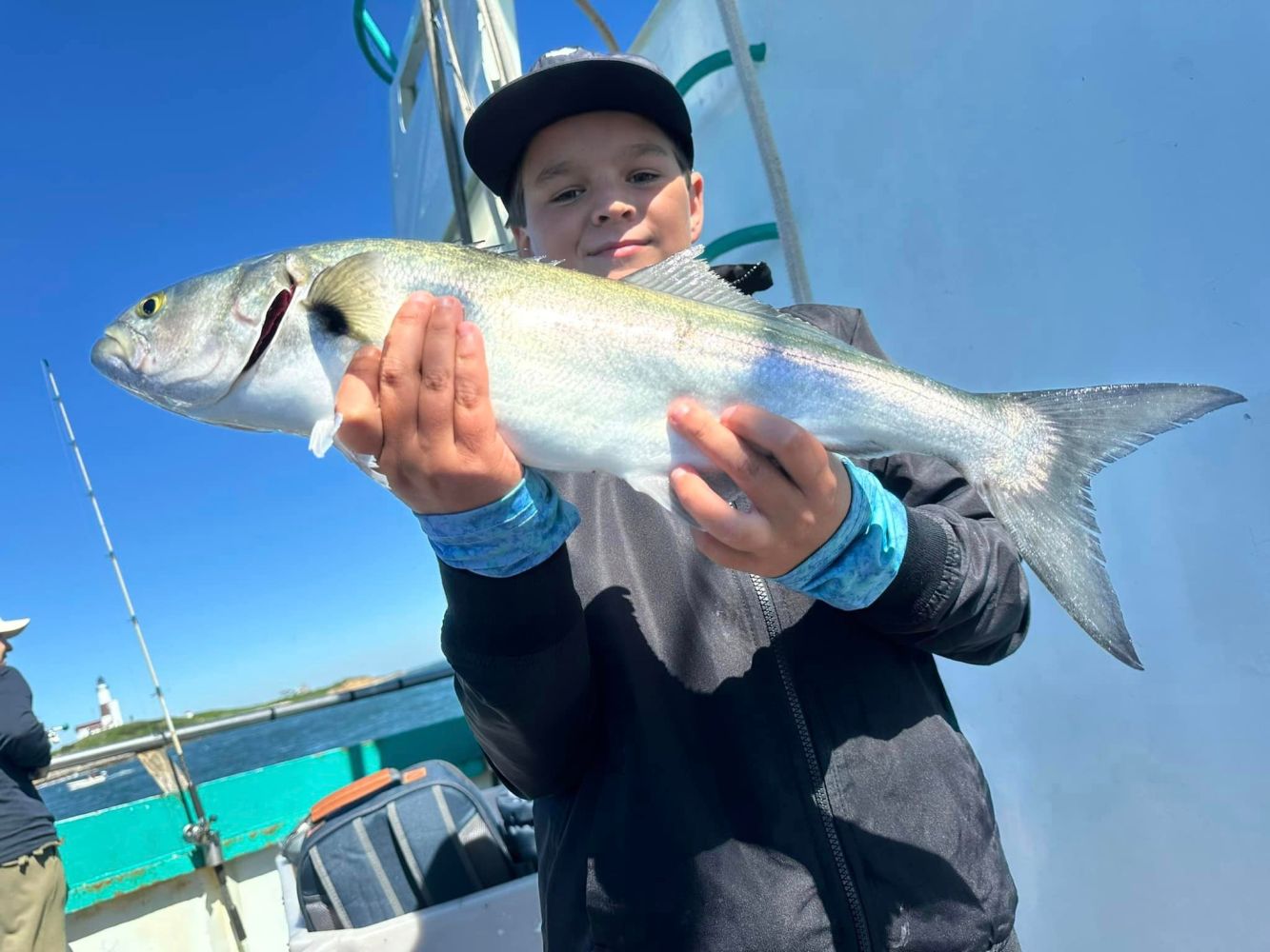 a young boy holding a fish in the water