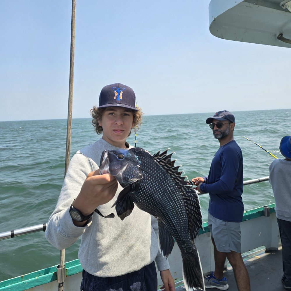 a person holding a fish on a boat in a body of water