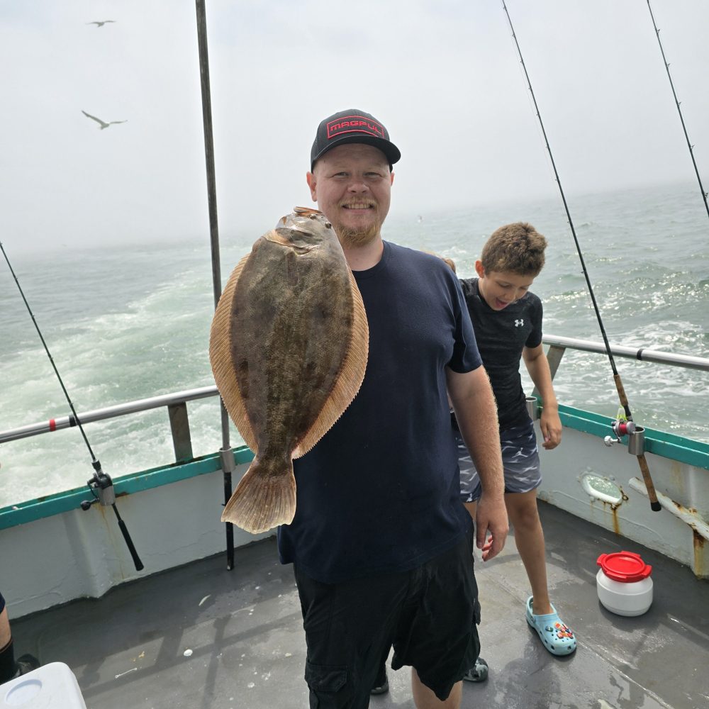 a man holding a fish on a boat