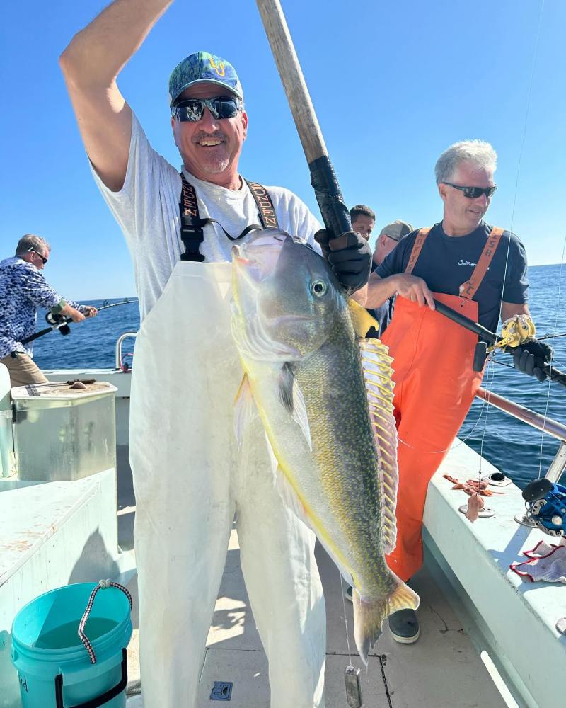 a man holding a fish on a boat