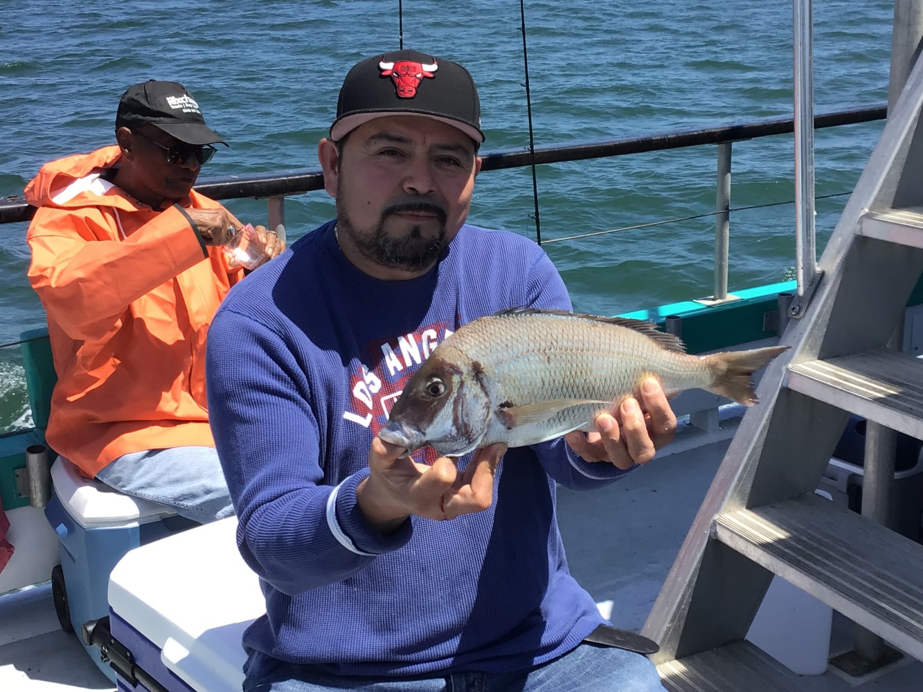 a person holding a fish on a boat in the water