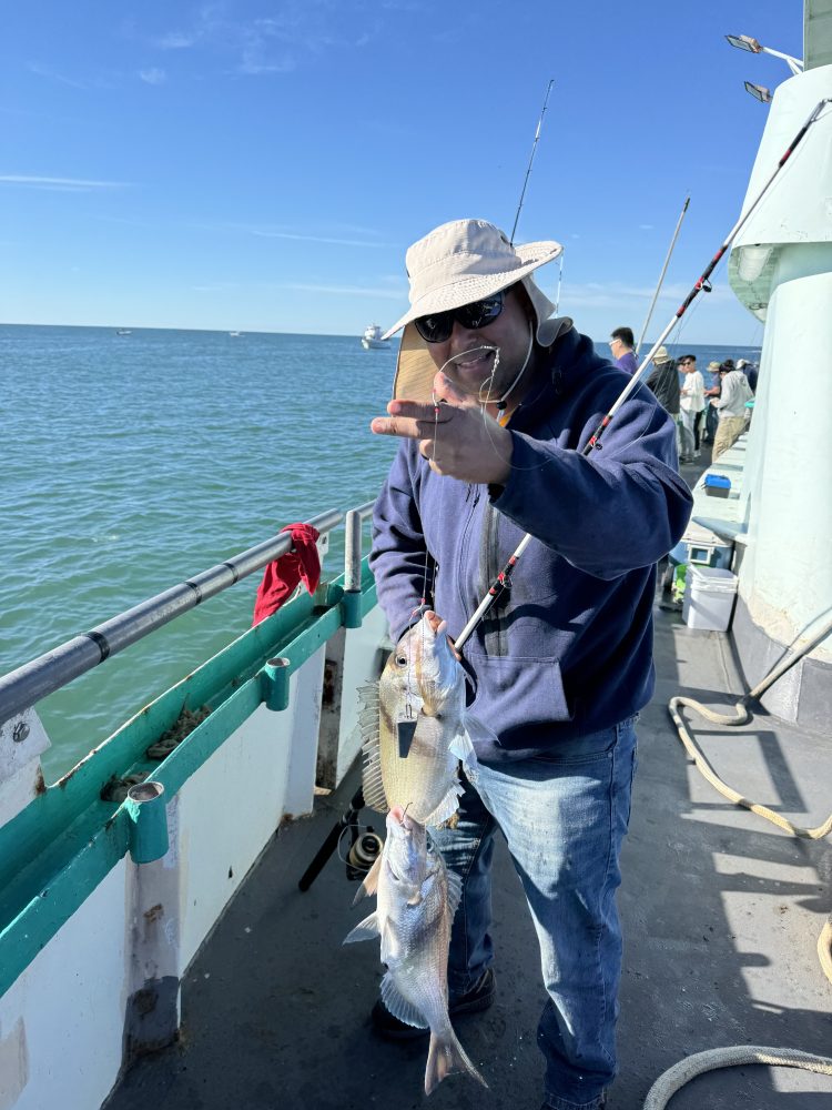 a man holding a fish on a boat