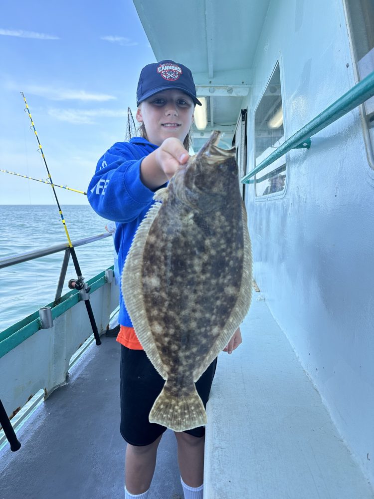 a young boy holding a fish