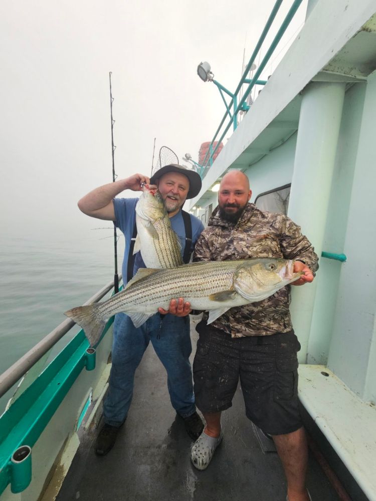 a man holding a fish on a boat