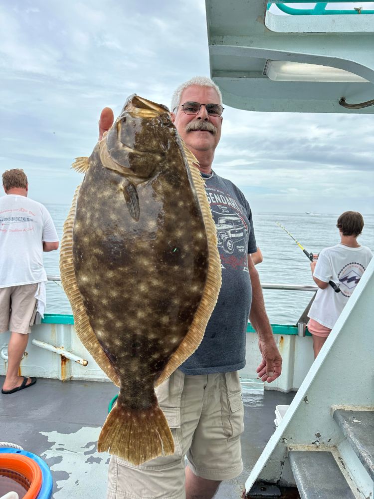 a person holding a fish on a boat