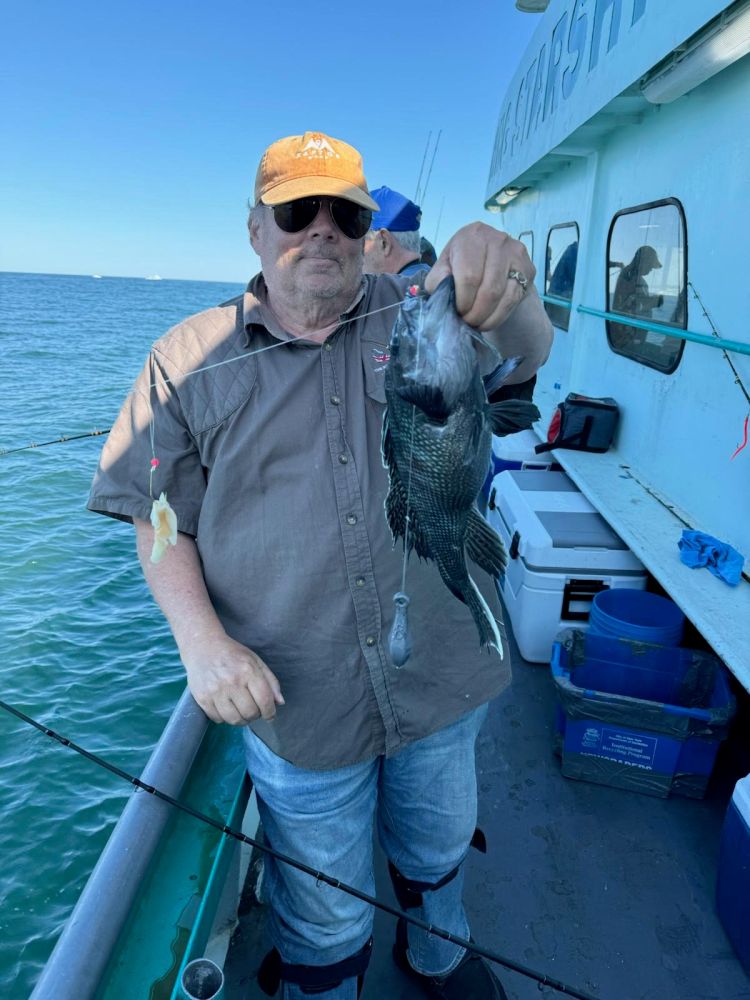 a man holding a fish on a boat