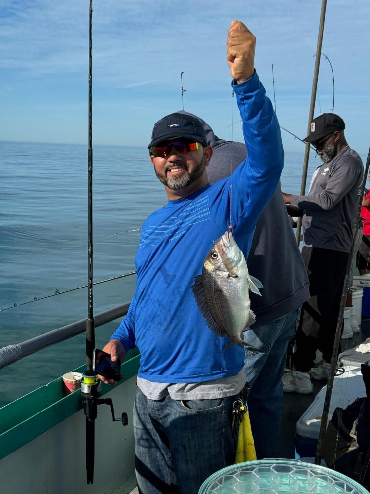 a person holding a fish on a boat