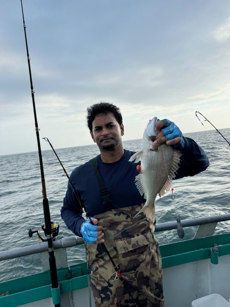 a man holding a fish in the water