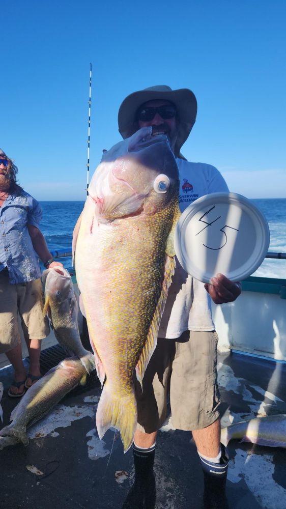 a man holding a fish on a boat