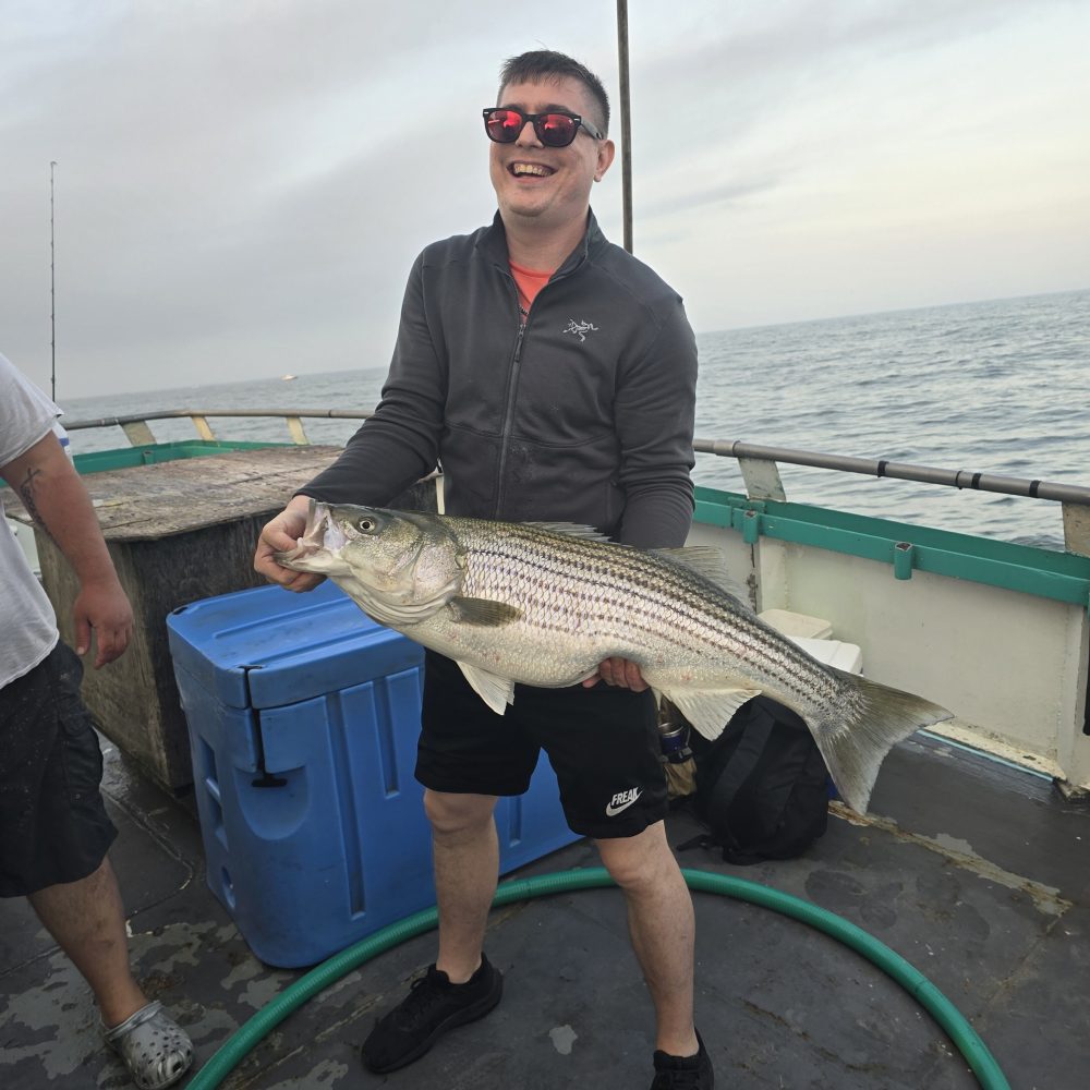 a man holding a fish on a boat