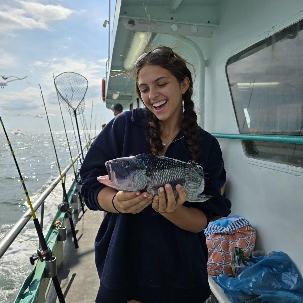 a person holding a fish on a boat