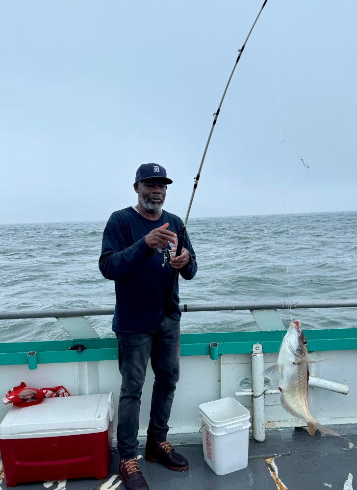 a man standing next to a body of water