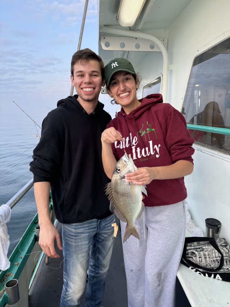 a person holding a fish posing for the camera