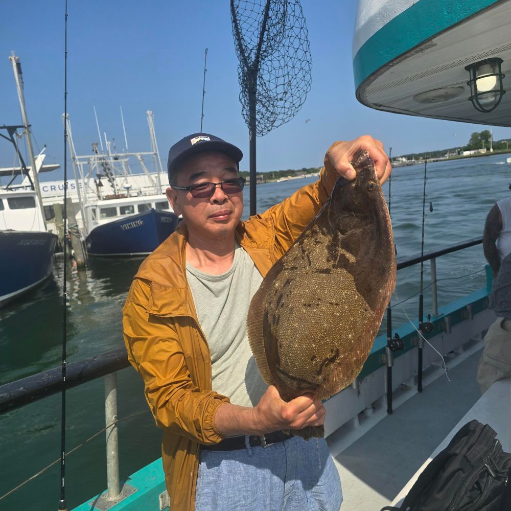 a person holding a fish on a boat posing for the camera