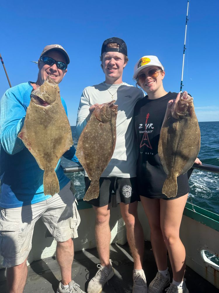 a group of people standing next to a person holding a fish