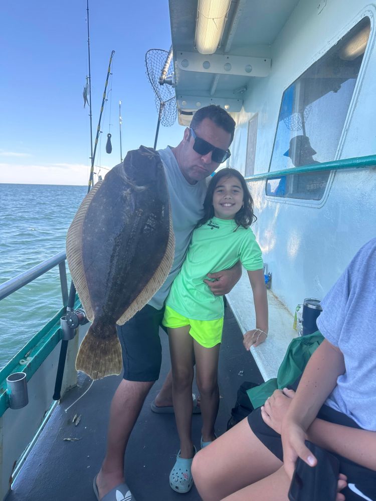 a person holding a fish on a boat posing for the camera