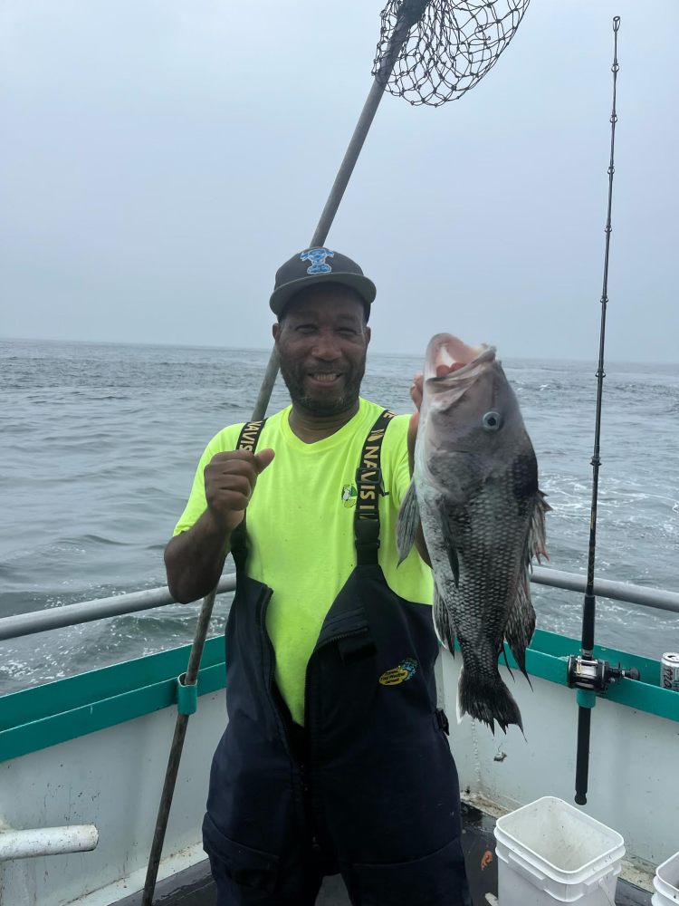 a person holding a fish on a boat