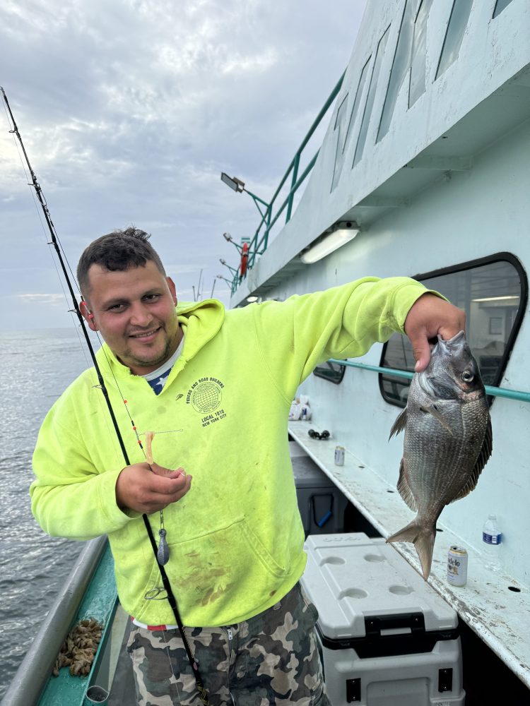 a person holding a fish on a boat