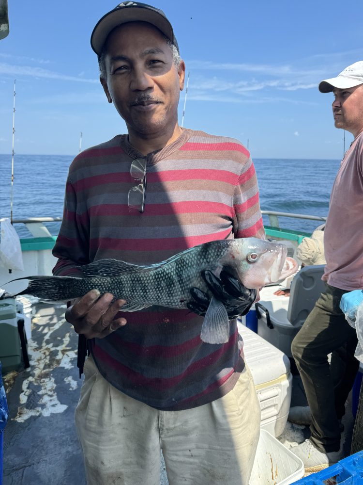 a person holding a fish on a boat in the water